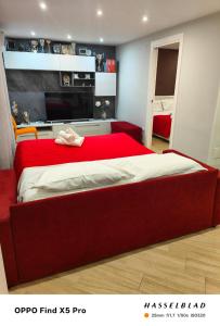 a bedroom with a red bed with a red head board at A Casa di Maria 2 in Cavallino di Lecce