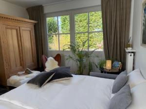 a bedroom with a white bed and a large window at Art'Aviation Guesthouse in Beauvechain