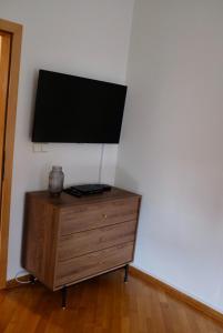 a wooden dresser with a flat screen tv on a wall at Apartman Spanish Square in Mostar