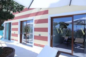 a store front with a red and white striped wall at WANDERLUST OASI, COUNTRYSIDE APARTMENTS - Bardolino, Lago di Garda - Verona in Bardolino