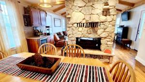 a living room with a table and chairs and a stone fireplace at The Fireside Lakehouse in Bridgeport