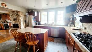 a kitchen with a counter and some chairs in it at The Fireside Lakehouse in Bridgeport