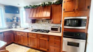 a kitchen with wooden cabinets and a stove top oven at The Fireside Lakehouse in Bridgeport