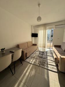 a living room with a couch and a table at Eki Apartments in Sarandë