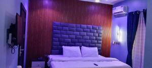 a bedroom with a large bed with a large headboard at Transvent Hotel and Suites in Abeokuta