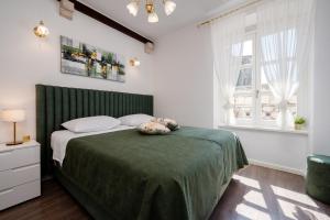 a bedroom with a bed with a green headboard at Palace Central Square in Trogir