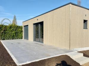 a wooden building with a concrete patio at Au loft, micro maison vue sur prairie in Rohrwiller