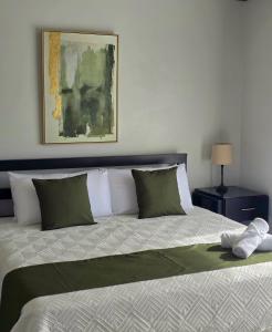 a bedroom with a large bed with green and white pillows at Casa del Lago #3 in Upala