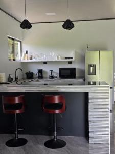 a kitchen with two red bar stools at a counter at Casa del Lago #3 in Upala