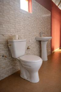 a bathroom with a toilet and a sink at Campement Clair de Lune - Chez Dam et Amcé in Kachiouane