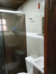 a bathroom with a shower and a toilet and a sink at Chalés FRONT LAKE 2 in Córrego do Bom Jesus +20 photos