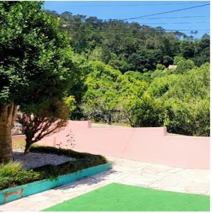 a yard with a tree and a pink wall at Casa Rosa da Serra in Sintra