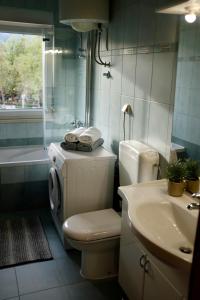 a bathroom with a toilet and a sink and a tub at Apartman Spanish Square in Mostar +12 photos