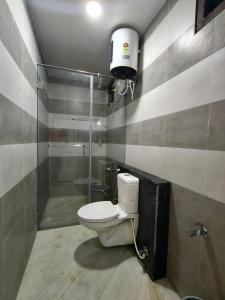 a bathroom with a toilet and a shower at Sekar Inn in Arumuganeri