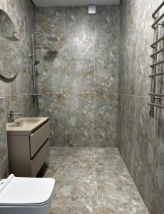 a bathroom with a shower and a toilet and a sink at Franko Aparts in Uzhhorod