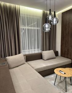 a living room with a couch in front of a window at Franko Aparts in Uzhhorod