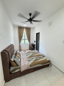 a bedroom with a bed with a ceiling fan at KY Stay D'Serkam in Serkam