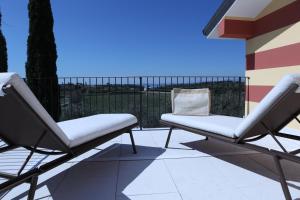 a pair of chairs sitting on a balcony at WANDERLUST OASI, COUNTRYSIDE APARTMENTS - Bardolino, Lago di Garda - Verona in Bardolino +97 photos