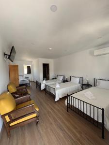 a hotel room with three beds and a couch at Ribeirinha in Lousã