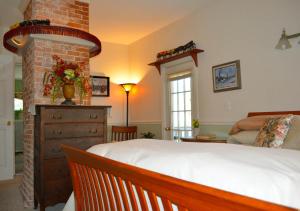 um quarto com uma cama e uma lareira de tijolos em Pryor House B&B em Bath