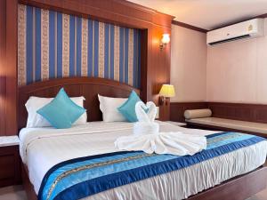 a bedroom with a bed with blue and white pillows at The Lion King Hotel by Thai Baan Ozone Udonthani in Udon Thani
