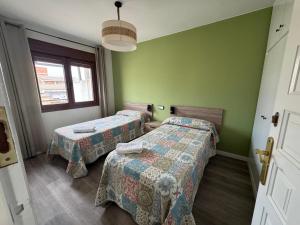 two beds in a room with green walls at Casa Herrero Valderrobres in Valderrobres