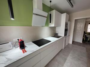 a kitchen with white cabinets and a red backpack on the counter at Casa Herrero Valderrobres in Valderrobres