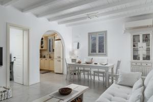 a white living room with a white couch and a table at West Side Garden House in Gavrio