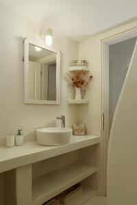 a bathroom with a sink and a mirror at West Side Garden House in Gavrio +16 photos