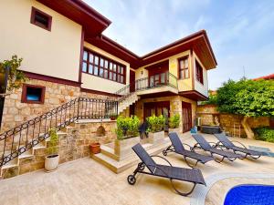 a house with a swimming pool and some chairs at Attalos Villa in Antalya