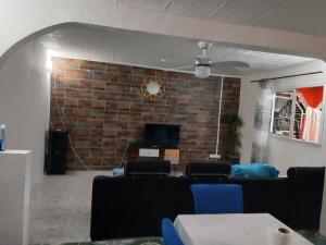 a living room with a couch and a brick wall at Les Jasmins partagées in Mamoudzou