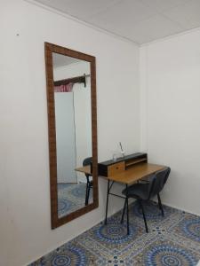 a mirror on a wall next to a desk and a table at Les Jasmins partagées in Mamoudzou