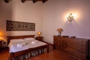 a bedroom with a bed and a dresser and a lamp at Casa Milly in Alghero