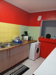 a kitchen with a sink and a washing machine at Les Jasmins partagées in Mamoudzou +4 photos