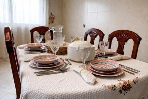 a table with a white table cloth with plates and glasses at Luxury Villa, 3 Levels, 5 bedrooms, 5 Baths, Pool & Garden in Tétouan