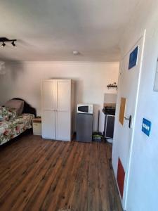 an empty room with a kitchen and a refrigerator at Adventure Cape Town 1 in Cape Town