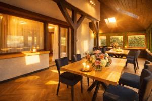 a dining room with a wooden table with flowers and candles at Dom Perełka w Karpaczu BASEN,SAUNA in Karpacz