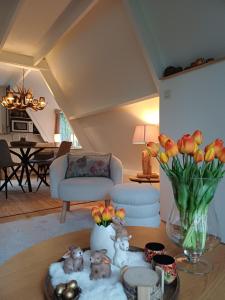 a living room with a table with a vase of flowers at Maison Tronchiennes in Durbuy