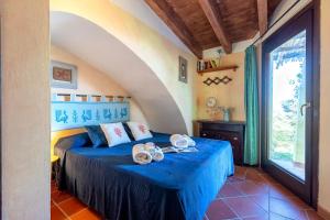 a bedroom with a bed with blue sheets and a window at Villa Belvedere Saline - Private Pool in Stintino +35 photos
