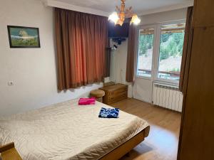 a bedroom with a bed with two bags on it at Къща Ники in Stoykite
