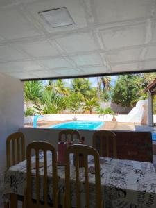 a dining room with a table and chairs and a pool at Aconchego&Lazer in Piaçabuçu +14 photos