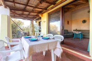 a table and chairs on a patio with a table and chairsktop at Villa Belvedere Saline - Private Pool in Stintino