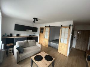 a living room with a couch and a kitchen at Apartament w centrum in Krotoszyn