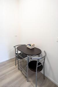 a table and chairs in a room with a white wall at Prestige House 9 in Scalea