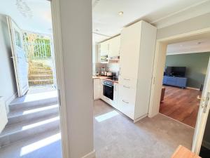 a kitchen with white cabinets and a staircase in a room at Amaroo - Serviced Apartment "Andy" in Potsdam +16 photos