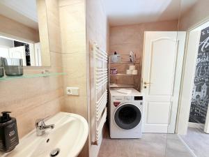 a bathroom with a washing machine and a sink at Amaroo - Serviced Apartment "Andy" in Potsdam