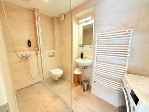 a bathroom with a shower and a toilet and a sink at Amaroo - Serviced Apartment "Andy" in Potsdam