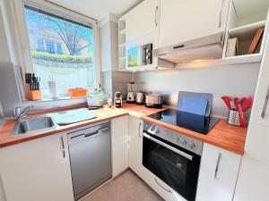 a kitchen with a sink and a stove top oven at Amaroo - Serviced Apartment "Andy" in Potsdam