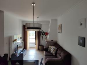 a living room with a couch and a chandelier at Quinta dos Carvalhais - Serra da Estrela in Fornos de Algodres