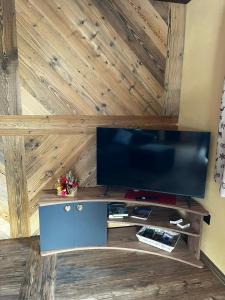a flat screen tv sitting on top of a wooden wall at Lo Boneur in Torgnon